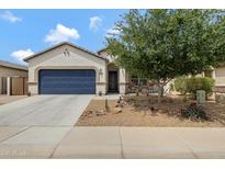Inviting single-story home featuring a desert landscape, a blue garage door, and a covered porch at 18366 N Arbor Dr, Maricopa, AZ 85138
