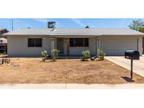 Charming single-story home with tidy landscaping, light gray paint, and an attached two-car garage at 18427 N 32Nd Ln, Phoenix, AZ 85053