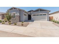 Charming single-Gathering home featuring a two-car garage, stone accents, and professionally landscaped front yard at 3260 W Caleb Rd, Phoenix, AZ 85083