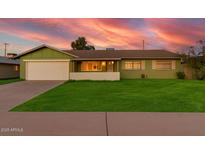 Beautiful one-story home with a lush green lawn, mature landscaping, and an attached two-car garage at 4004 W Myrtle Ave, Phoenix, AZ 85051