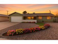 Charming one-story home featuring colorful flower beds, a well-maintained gravel yard, and a two-car garage at 4004 W Myrtle Ave, Phoenix, AZ 85051