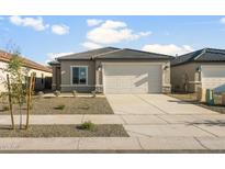 Charming single-story home with a two-car garage and low-maintenance desert landscaping in the front yard at 42875 W Vincent Dr, Maricopa, AZ 85138