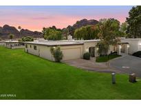 Charming single-story home with a well-manicured lawn and desert landscaping, set against a backdrop of mountains at 6055 E Vernon Ave, Scottsdale, AZ 85257