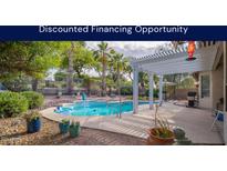 Backyard view featuring a sparkling pool, lush landscaping, patio with pergola and outdoor seating at 835 W Beechnut Dr, Chandler, AZ 85248