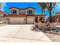 Charming two-story home featuring a spacious three-car garage and well-manicured landscaping at 12375 W Meadowbrook Ave, Avondale, AZ 85392