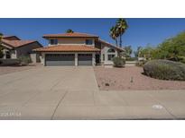 Inviting two-story home with a gray two-car garage, red tile roof, and well-maintained front yard at 15828 N 10Th Pl, Phoenix, AZ 85022