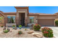Charming single-story home with desert landscaping, flowers, and a tile roof at 18547 W Sweet Acacia Dr, Goodyear, AZ 85338