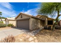 Charming single-story home with a two car garage, landscaped front yard, and light beige stucco exterior at 2153 E Crest Ln, Phoenix, AZ 85024