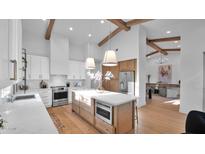Bright, modern kitchen with an island, stainless steel appliances, and wooden beam accents at 5103 E Juniper Ave, Scottsdale, AZ 85254
