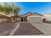 Charming single-story home featuring a desert landscape, two-car garage, and stone accents at 6244 E Inglewood St, Mesa, AZ 85205