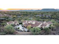 Expansive desert home featuring an outdoor living space, fire pit, lush landscaping, and mountain views at 7753 E Whisper Rock Trl, Scottsdale, AZ 85266