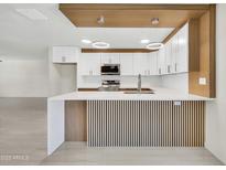 Modern kitchen with white cabinets, stainless steel appliances, and a stylish waterfall countertop at 8146 N 17Th Dr, Phoenix, AZ 85021