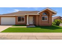 Charming single-story home featuring a manicured lawn and attached two-car garage at 915 E Annette Dr, Phoenix, AZ 85022