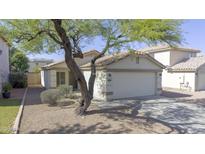 Charming single-story home with a well-maintained yard and attached two-car garage at 12046 W Flores Dr, El Mirage, AZ 85335