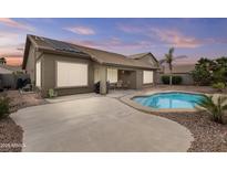 Inviting backyard featuring a pool, patio, and lush landscaping perfect for outdoor relaxation and entertaining at 12214 W Madison St, Avondale, AZ 85323