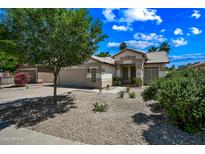 A charming single-story house is presented with well-maintained desert landscaping and a two-car garage at 13857 W Windsor Ave, Goodyear, AZ 85395