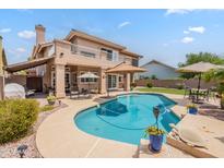 Backyard pool area featuring a desert landscape with a large two story home in the background at 1667 E Saltsage Dr, Phoenix, AZ 85048
