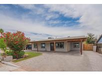 Inviting single-Gathering home with a spacious front yard, covered parking, manicured lawn, and blooming flowers at 1861 N 63Rd Ave, Phoenix, AZ 85035