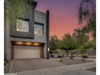 Contemporary home with a stone-accented garage and inviting curb appeal at dusk at 1910 W Desert Hollow Dr, Phoenix, AZ 85085