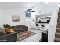 Bright living room featuring high ceilings, ceiling fan, and an open floor plan connecting to the kitchen at 2201 N Comanche Dr # 1093, Chandler, AZ 85224