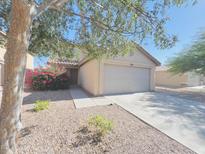 Charming single-Gathering home with a two-car garage and desert landscaping, featuring a vibrant flowering bush near the entrance at 22311 W Woodlands Ave, Buckeye, AZ 85326
