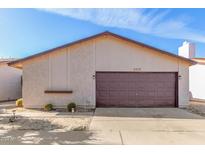 Charming single-story home showcasing a well-maintained two-car garage, xeriscaping, and a neutral color palette at 2635 W Hearn Rd, Phoenix, AZ 85023