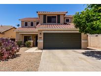 Inviting two-story home featuring a well-maintained front yard with a spacious two car garage at 27420 N 63Rd Dr, Phoenix, AZ 85083