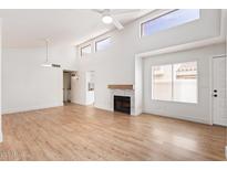 Bright living room featuring high ceilings, clerestory windows, a ceiling fan, a fireplace, and wood flooring at 2834 S Extension Rd # 2005, Mesa, AZ 85210