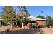 Charming single-story brick home with a well-maintained front yard, mature trees, and red rock landscaping at 3115 N 26Th St, Phoenix, AZ 85016