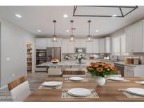 Modern kitchen features stainless steel appliances, a large island, and stylish pendant lighting at 316 N 78Th Pl, Mesa, AZ 85207