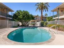 Beautiful community pool with lounge chairs, patio table and lush landscaping at a charming, well-maintained property at 3655 N 5Th Ave # 202, Phoenix, AZ 85013