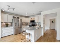 Bright kitchen boasts stainless steel appliances, marble countertops, and light wood flooring at 4430 E Creosote Dr, Cave Creek, AZ 85331