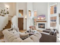 Bright living room features soaring ceilings, a cozy fireplace, and elegant furnishings at 4430 E Creosote Dr, Cave Creek, AZ 85331