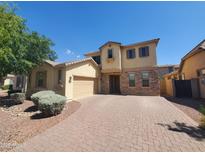 Charming two-story home featuring stone accents, a two-car garage, and a brick-paved driveway at 5635 W Huntington Dr, Laveen, AZ 85339
