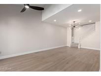 Spacious living room with high ceilings, modern fan, wood floors, and staircase at 6004 N 79Th St, Scottsdale, AZ 85250