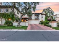 Attractive two-story home with a terracotta roof, lush landscaping, private balconies and a red brick driveway at 6701 N Scottsdale Rd # 26, Scottsdale, AZ 85250