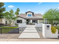 Stunning white home featuring a modern design, desert landscaping, and a welcoming walkway at 101 E Linger Ln, Phoenix, AZ 85020