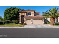 Inviting two-story home featuring a two-car garage, manicured lawn, and desert landscaping at 2224 W Olive Way, Chandler, AZ 85248