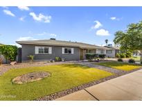 Well-maintained single-story home featuring xeriscaped front yard with lush, green, artificial lawn at 2715 E Edgemont Ave, Phoenix, AZ 85008