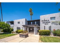 Sierra Grande building exterior with palm trees and manicured landscaping on a sunny day at 3230 E Pinchot Ave # 32, Phoenix, AZ 85018
