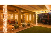 Inviting covered patio featuring charming lights and a cozy seating area, perfect for outdoor relaxation at 42311 W Good Vibrations Ln, Maricopa, AZ 85138
