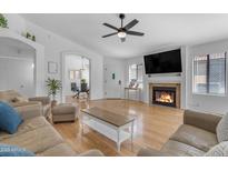 Bright living room with hardwood floors, fireplace and TV, creating a cozy and inviting space at 4519 E Amberwood Dr, Phoenix, AZ 85048