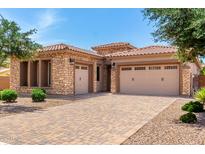 Beautiful desert home featuring a tile roof, stone accents, and a spacious three-car garage at 5446 S Sandstone Ct, Gilbert, AZ 85298