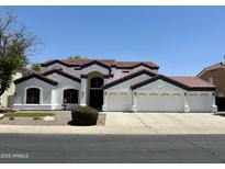 Charming two-story home with a three car garage, manicured lawn, and desert landscaping at 579 N Mondel Dr, Gilbert, AZ 85233
