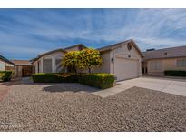 Charming single-story home featuring a well-manicured lawn, flowering trees, and a two-car garage at 5924 W Shangri La Rd, Glendale, AZ 85304