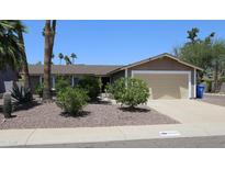 Single-story home with a two-car garage, desert landscaping, and palm trees at 6920 E Beverly Ln, Scottsdale, AZ 85254