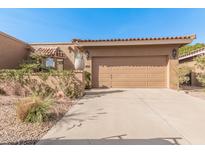 Tan home exterior with a red tile roof, complemented by desert landscaping and a spacious two-car garage at 10626 N 8Th St, Phoenix, AZ 85020