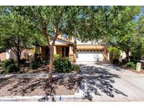 Charming two-story home featuring an attached two-car garage and mature landscaping in the front yard at 13722 N 150Th Ln, Surprise, AZ 85379