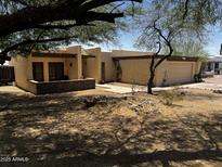 Inviting single-story home with stucco exterior, attached garage, and covered porch with stone accents at 1541 E Las Palmaritas Dr, Phoenix, AZ 85020