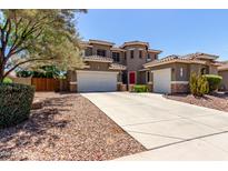 Stunning two-story home featuring a red door, three-car garage and drought tolerant landscaping at 4123 S Wayne Pl, Chandler, AZ 85249